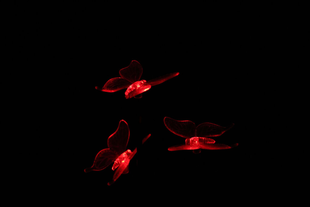 Captivating Wallpaper: Glowing Red Butterflies on Dark Branches