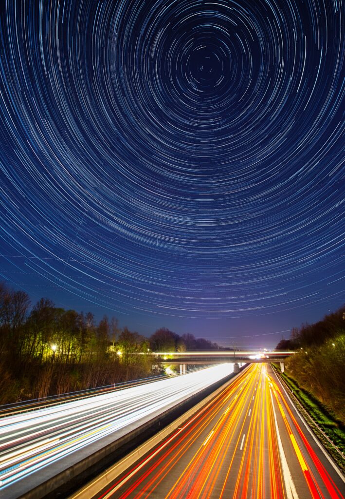 Stunning Starry Sky Road Wallpaper with Vibrant Light Trails