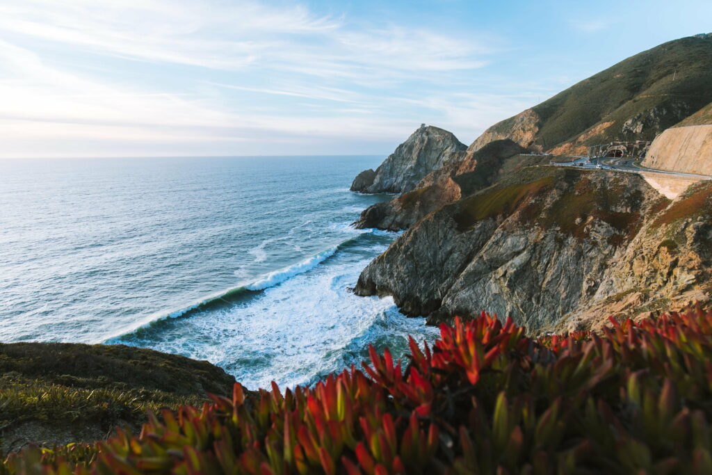 Devils Slide California coastline rugged cliffs Pacific Ocean red succulents Highway 1 tunnel view Wallpaper