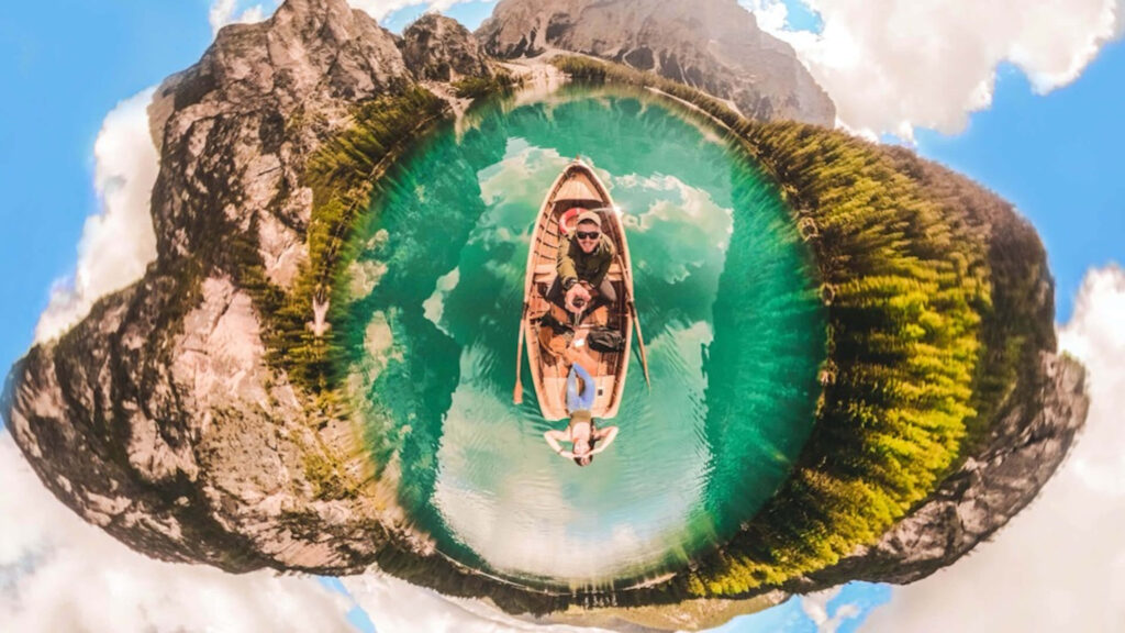 360 view of boat on turquoise water surrounded by mountains and lush greenery tiny planet effect Wallpaper