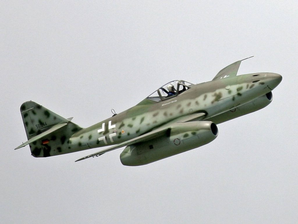 Messerschmitt Me 262 WWII jet fighter in flight with mottled camouflage against cloudy sky wallpaper