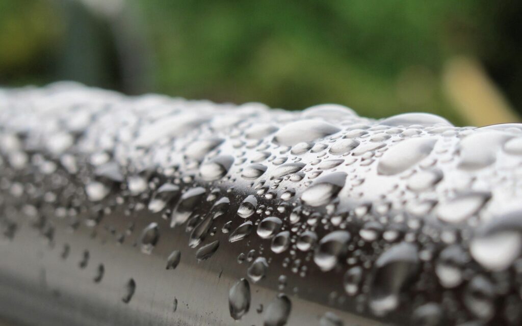 Metal Pipe with Water Droplets - Stunning Green Wallpaper Background