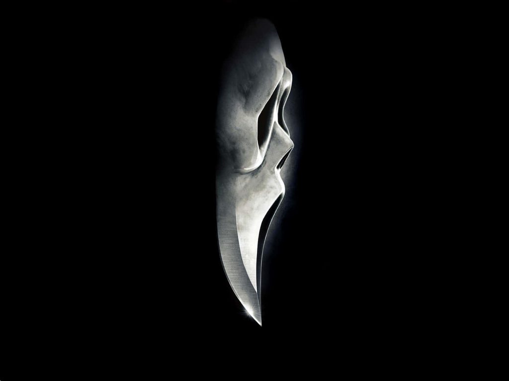 Metallic Ghostface mask side profile with blade chin and rim lighting on black background wallpaper