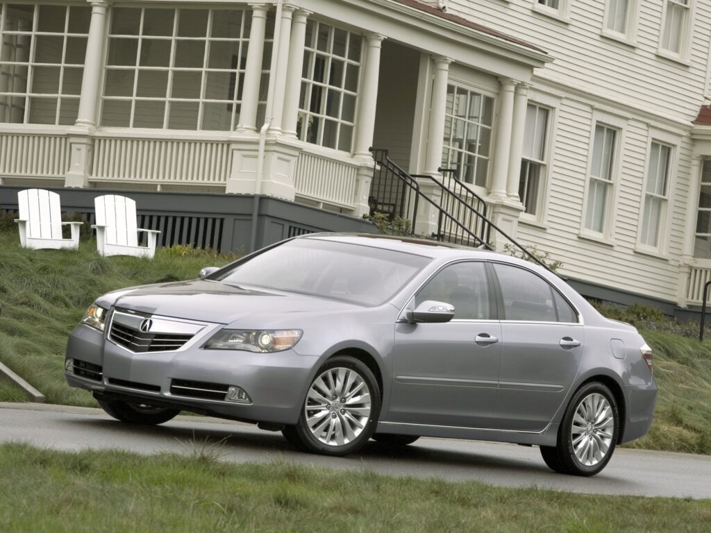 Elegant Metallic Gray Acura RL Parked by Classic Architecture Wallpaper