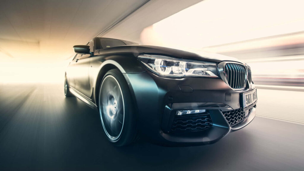 Gleaming Majesty: Explore the Allure of the Metallic Green BMW M760Li's Stunning Wheel and Headlights Wallpaper