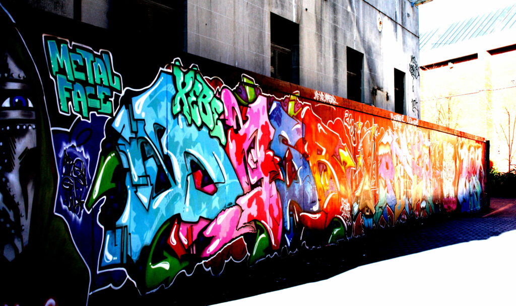 Vibrant Urban Masterpiece: Captivating Graffiti Art on a Metal Wall - HD Wallpaper