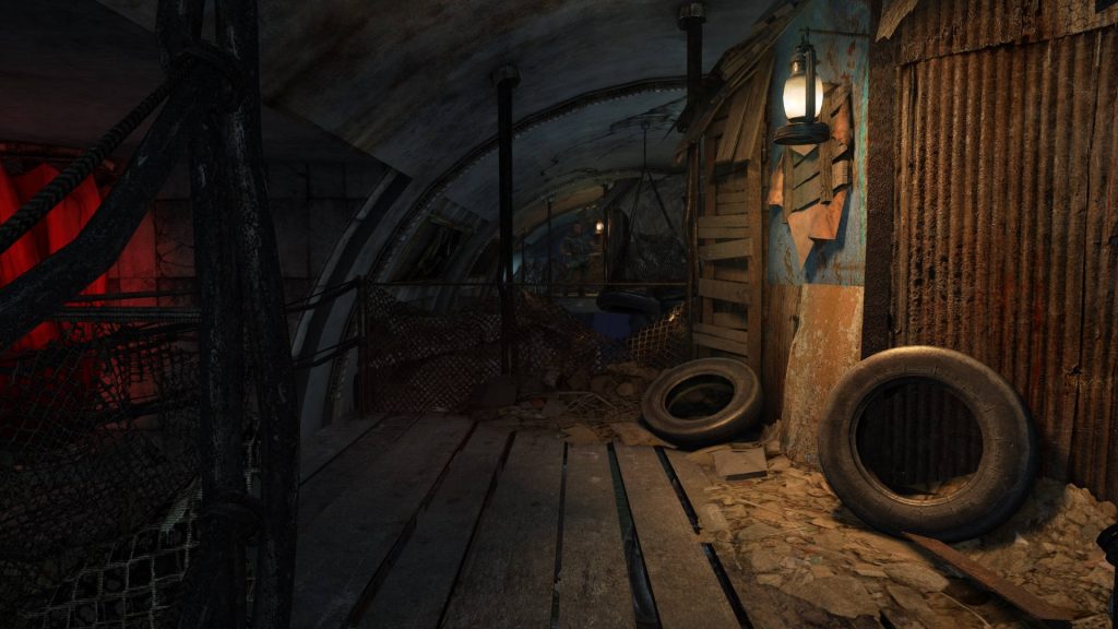 Dark underground tunnel with rusty walls glowing lantern and discarded tires Metro Last Light wallpaper