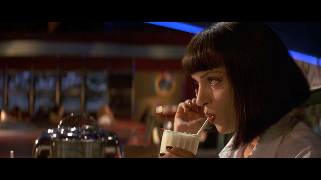 Retro Diner Wallpaper: Mia Wallace Sipping Milkshake - Pulp Fiction Art