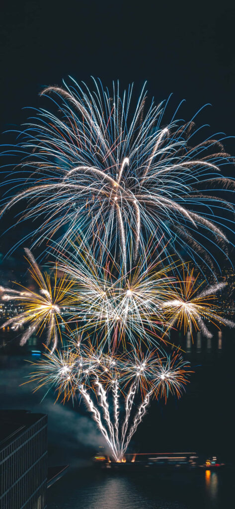 Colorful fireworks over Miami Lakes at night reflecting on water festive celebration wallpaper