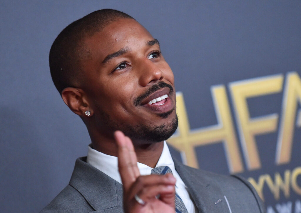 Dashing Michael B. Jordan exudes charm and positivity, flashing a peace sign on red carpet Wallpaper