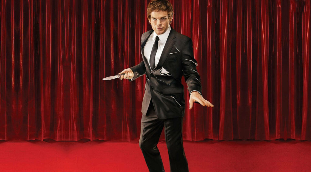 Michael C Hall as Dexter Morgan in black suit holding knife red curtain backdrop suspenseful wallpaper
