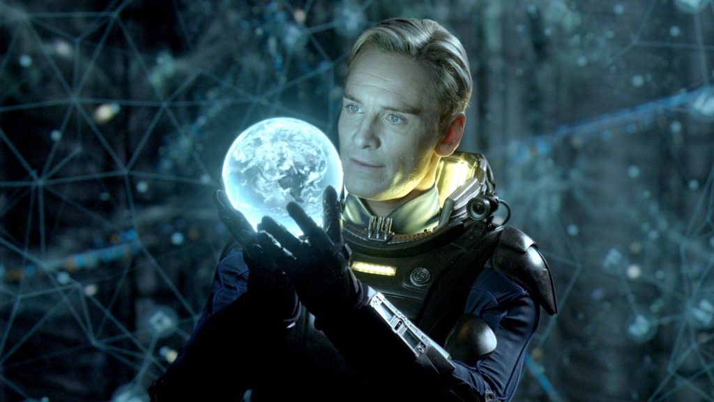 Michael Fassbender as android David in detailed space suit holding holographic planet sci-fi wallpaper