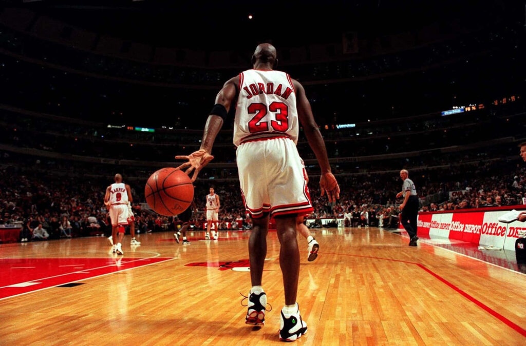 The Unstoppable Force: Michael Jordan Dominates the Court in the Iconic Bulls Jersey Wallpaper