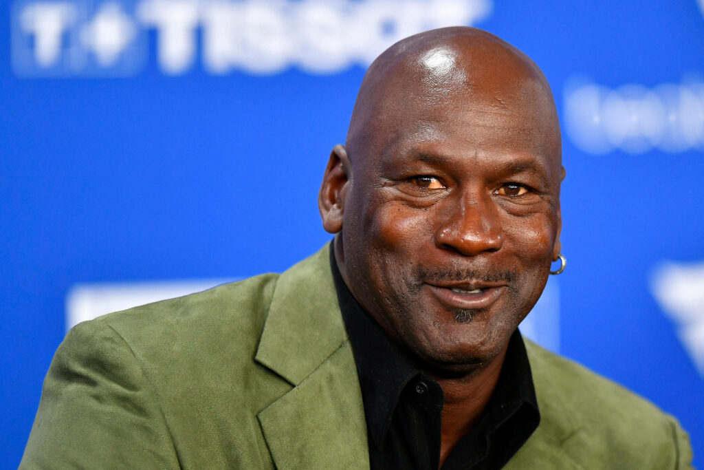 The Fashionable Attire of Michael Jordan: A Stylish Green Suit and Polo Combination for a Special Event Wallpaper