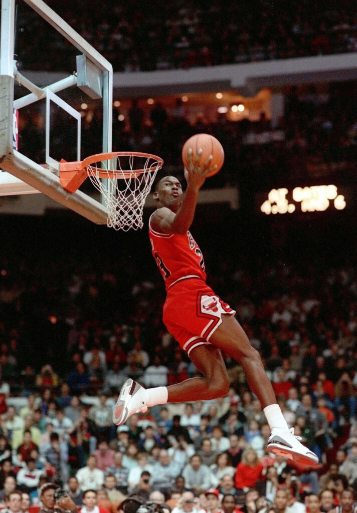 Airborne Majesty: Michael Jordan's Mid-Air Mastery on the Legendary Basketball Court Wallpaper