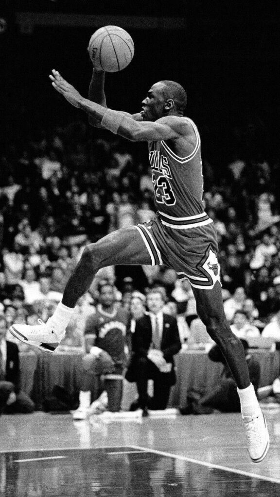 Airborne Elegance: Michael Jordan, The Legendary Phenom, Showcases His Iconic Dunking Prowess in Bulls Uniform for an Unforgettable Moment in Basketball History Wallpaper