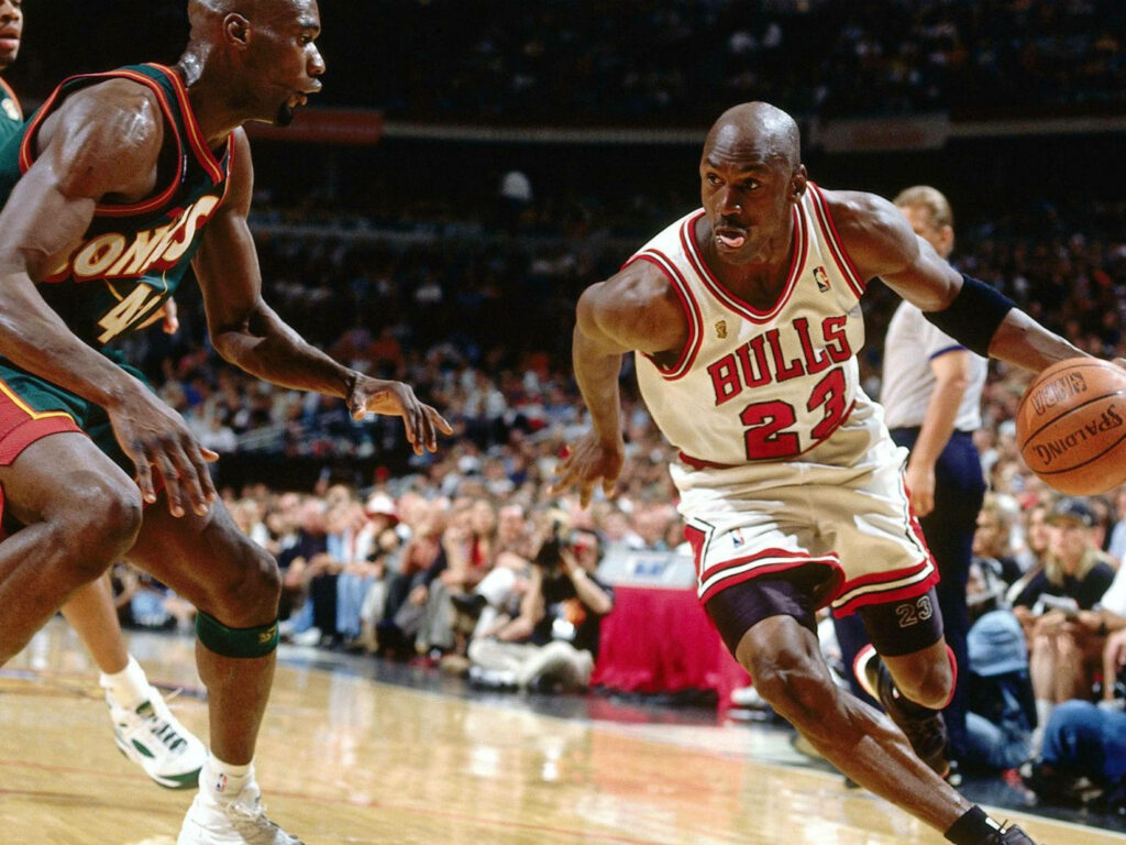 Michael Jordan in Action: Dribbling Towards Victory Wallpaper