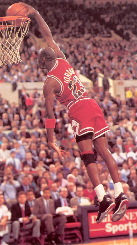Airborne Excellence: Michael Jordan Soars for Ultimate Dunk Wallpaper