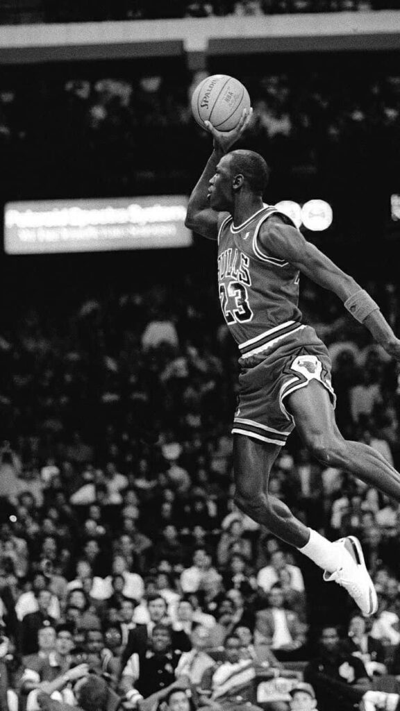Imposing Monochrome: Michael Jordan Ascends for a Slam Dunk Wallpaper