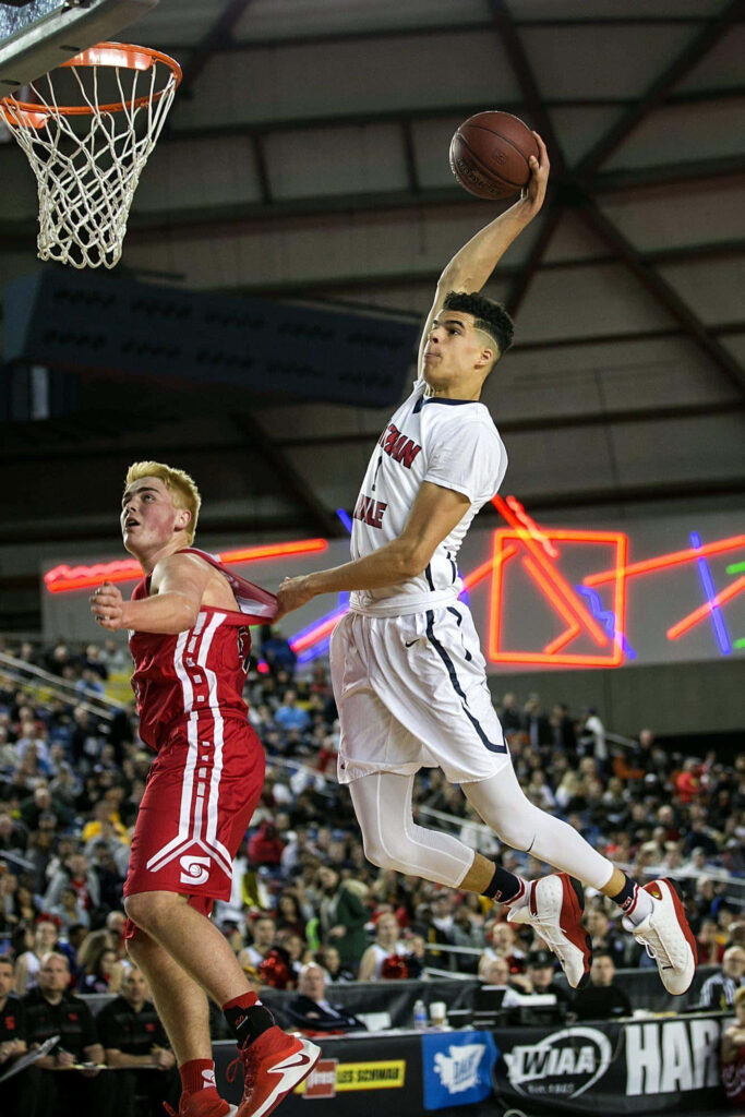 Michael Lamar Porter Jr soaring mid-air during intense basketball game with vibrant crowd background Wallpaper