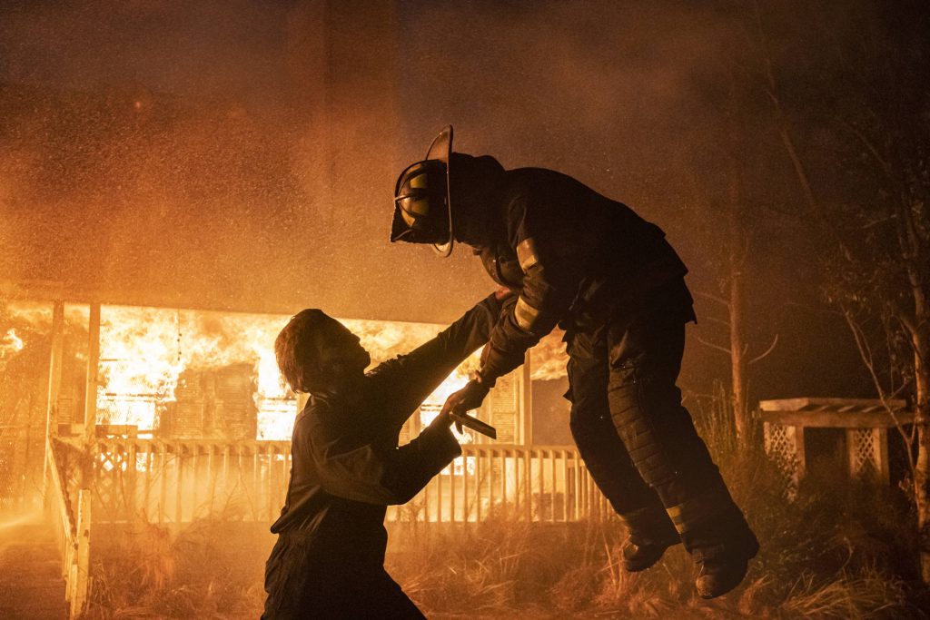 Michael Myers overpowering firefighter by blazing house fire Halloween Kills horror wallpaper