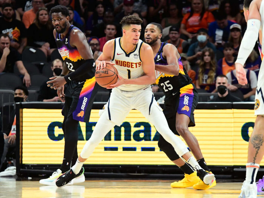 Michael Porter Jr dribbling past Phoenix Suns defenders Mikal Bridges and Deandre Ayton in NBA game Wallpaper