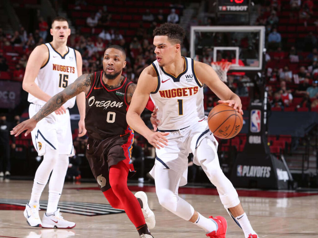 Michael Porter Jr driving past Damian Lillard in intense NBA playoff game with dynamic action Wallpaper