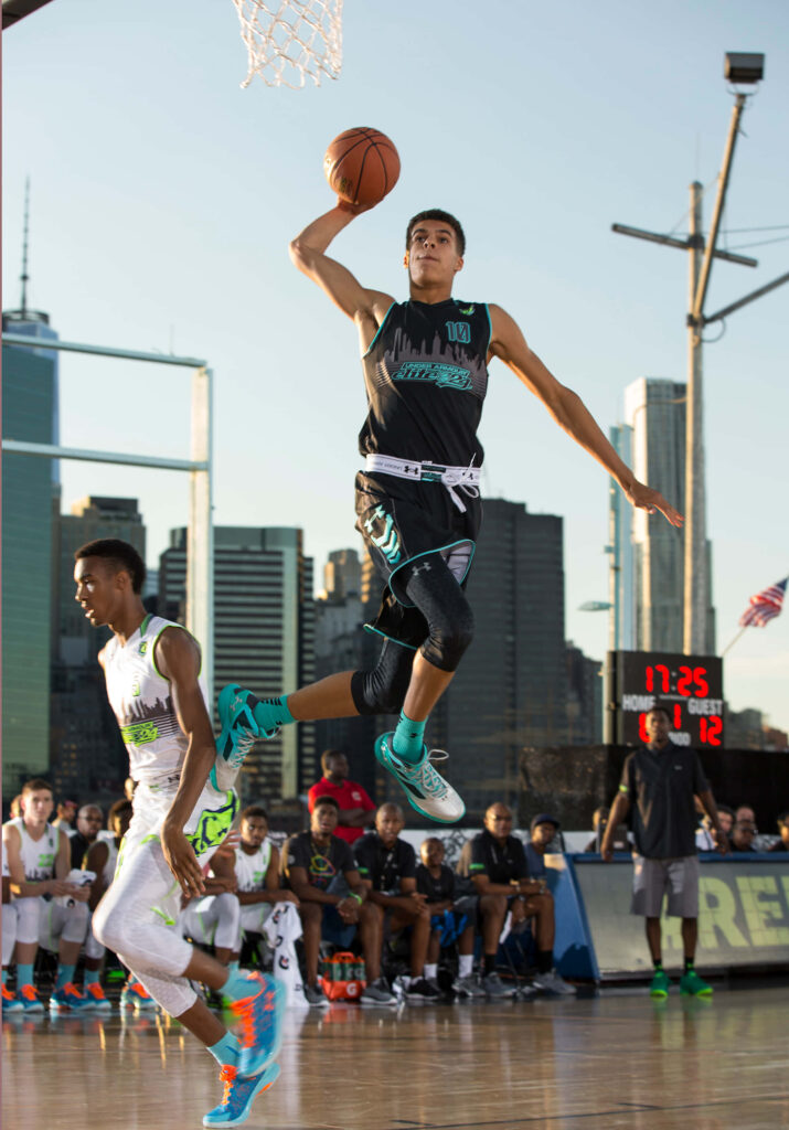 Michael Porter Jr. soaring for a powerful dunk on outdoor court with city skyline background Wallpaper