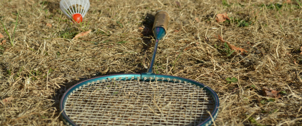 Badminton and Shuttlecock on Field Background Wallpaper