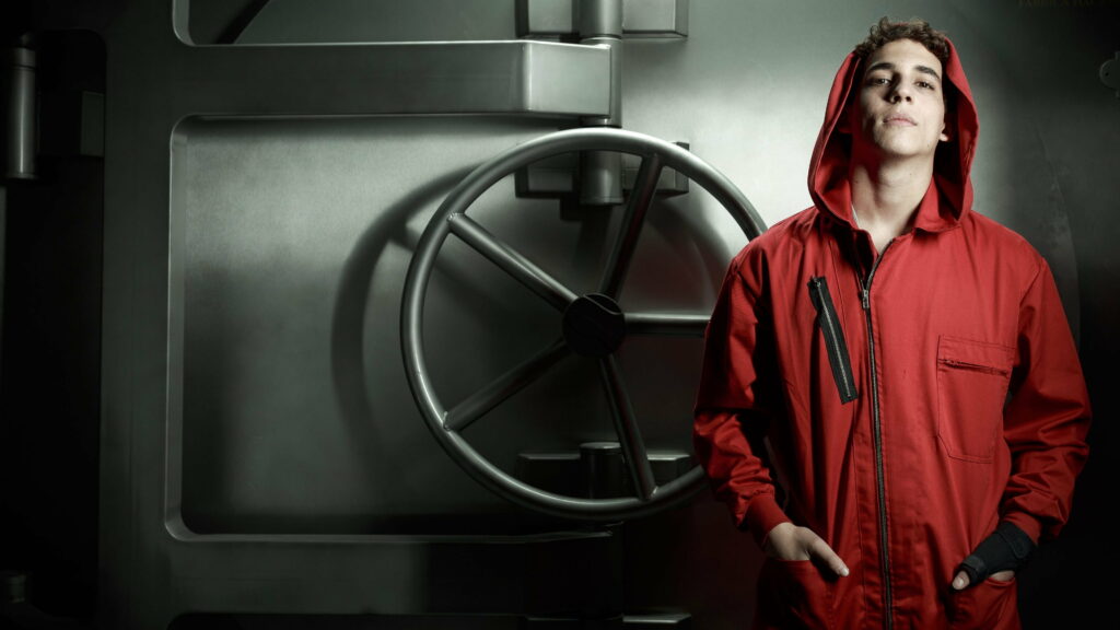 Miguel Herrán as Rio in red jumpsuit stands before industrial bank vault Money Heist 4K wallpaper