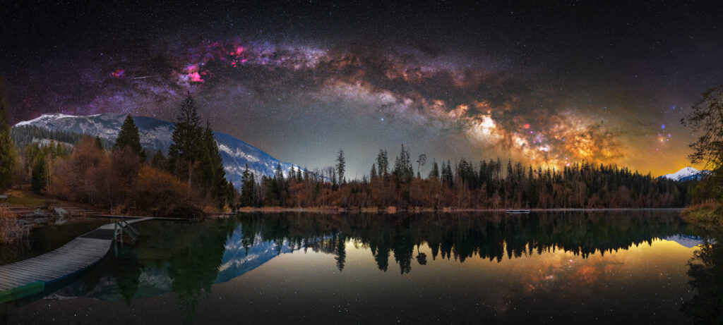 Milky Way night sky over mountains lake and forest reflected in water tranquil landscape wallpaper
