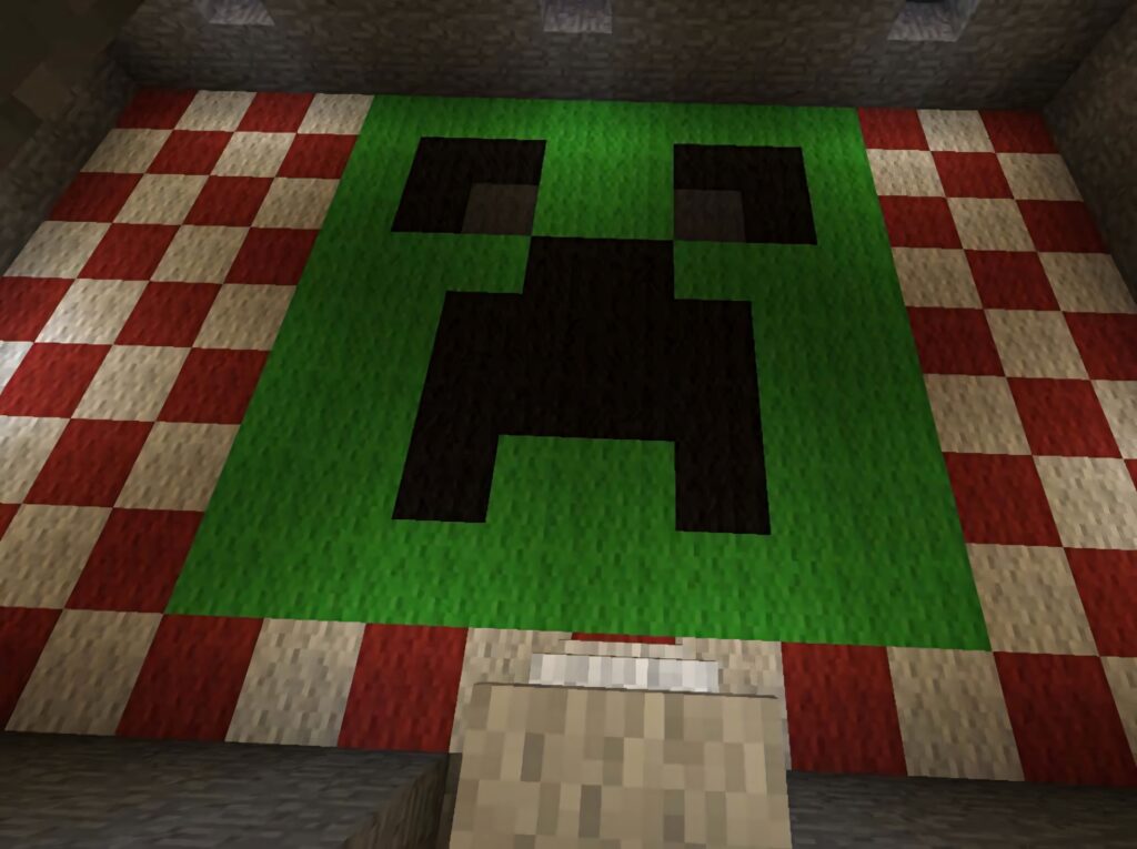 Close-up of Minecraft Creeper face with pixelated green black pattern on red white blocks background Wallpaper