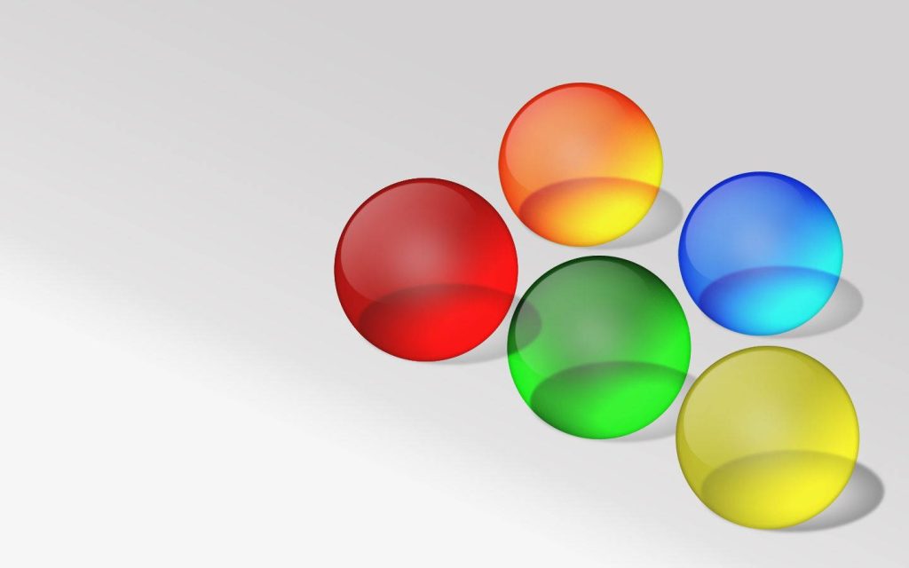 Minimalist 3D wallpaper with five vibrant translucent spheres in red orange green blue yellow on white background
