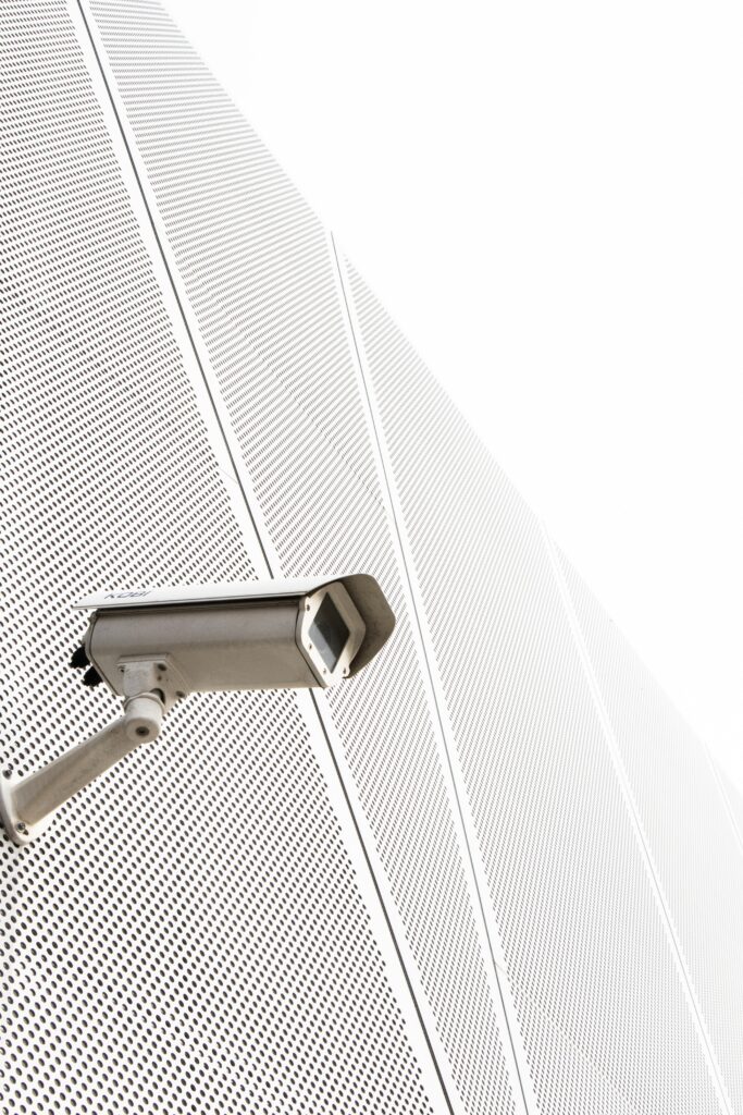 Sleek Surveillance Camera on Minimalist White Building Wallpaper