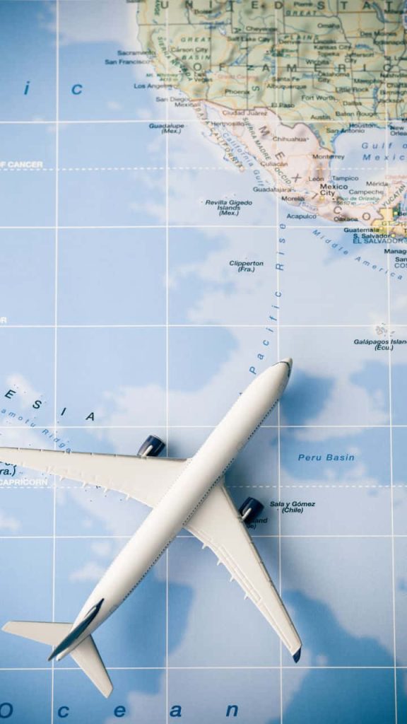 White airplane model over blue Pacific North America map travel wallpaper background minimalist