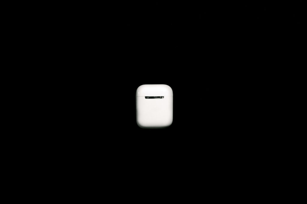 Minimalist Apple AirPods case wallpaper on black background showcasing sleek iconic design