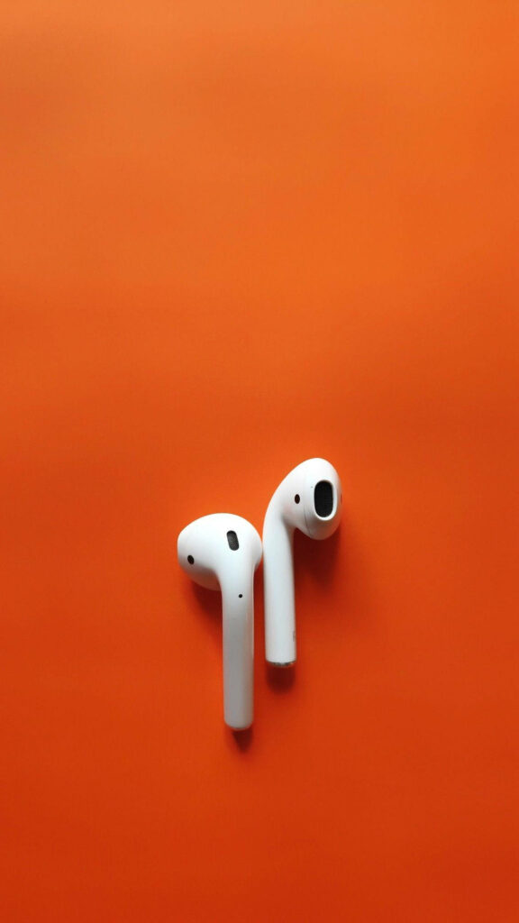 Minimalist Apple AirPods on vibrant orange background modern stylish tech wallpaper design