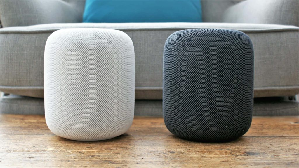 Two Apple HomePod smart speakers white and space grey on rustic wooden table modern setting Wallpaper