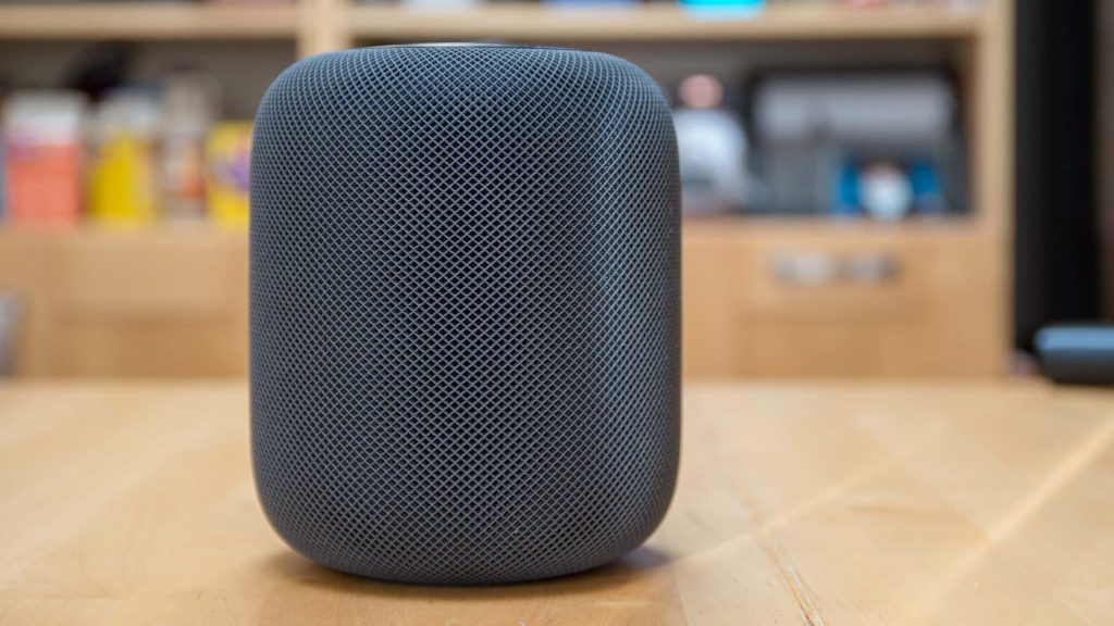 Apple HomePod smart speaker in space gray with mesh texture on wooden table close-up Wallpaper