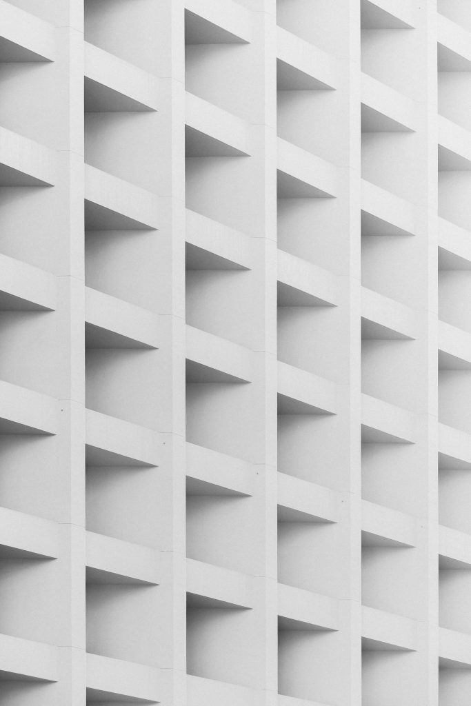Minimalist white facade with recessed square grid pattern and subtle geometric shadows background Wallpaper