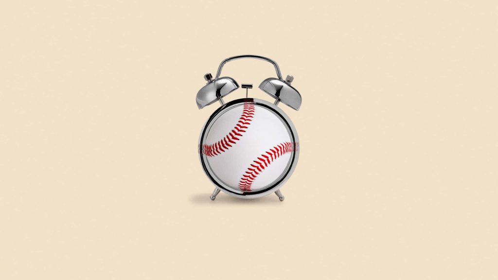 Minimalist silver alarm clock with baseball face red stitching on beige background wallpaper