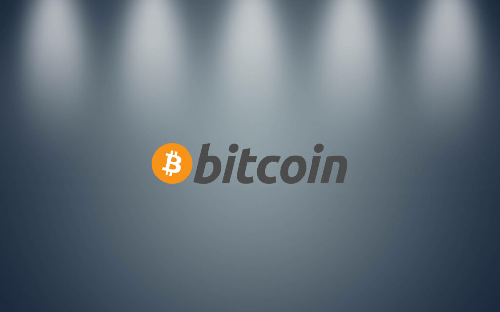 Minimalist Bitcoin wallpaper with orange white logo under soft spotlights symbolizing digital wealth