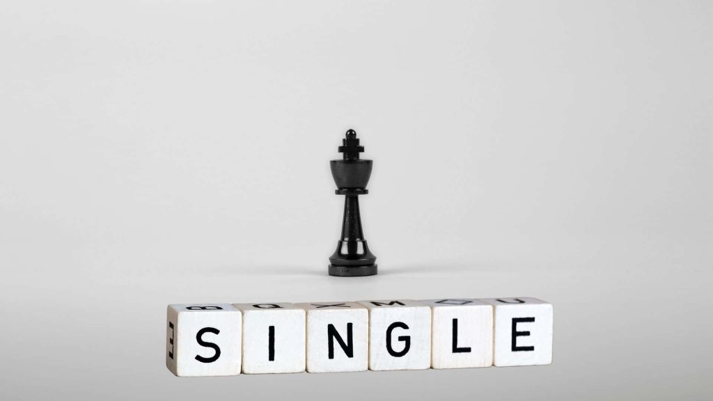 Black chess king behind wooden blocks spelling SINGLE symbolizing confidence and independence Wallpaper