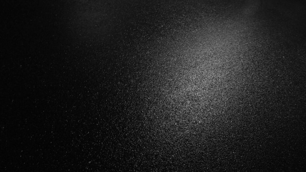 Minimalist Black Textured Wallpaper: Sleek Wet Asphalt Design