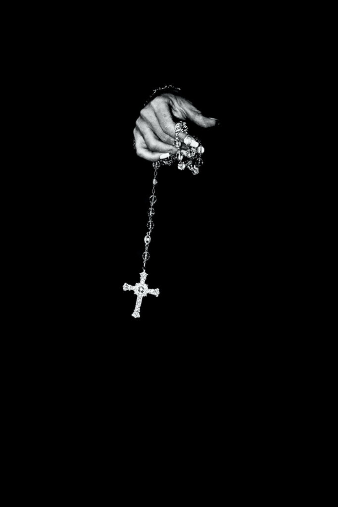 Minimalist Black Wallpaper: Hand Holding Rosary for iPhone Screens