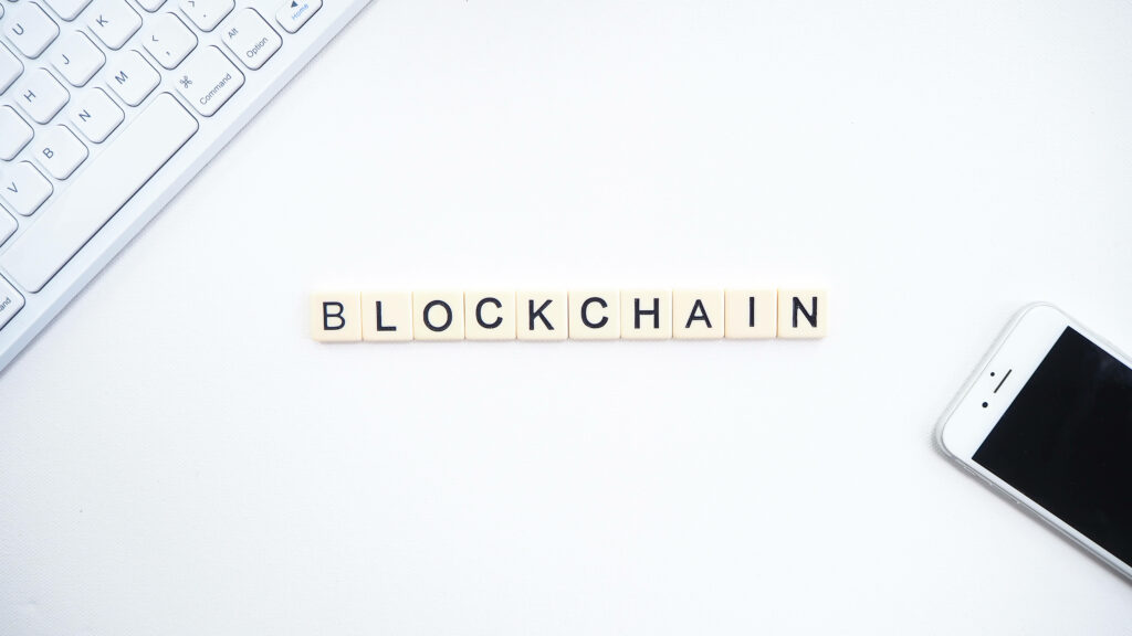 Minimalist Blockchain word tiles with smartphone and keyboard on white background wallpaper