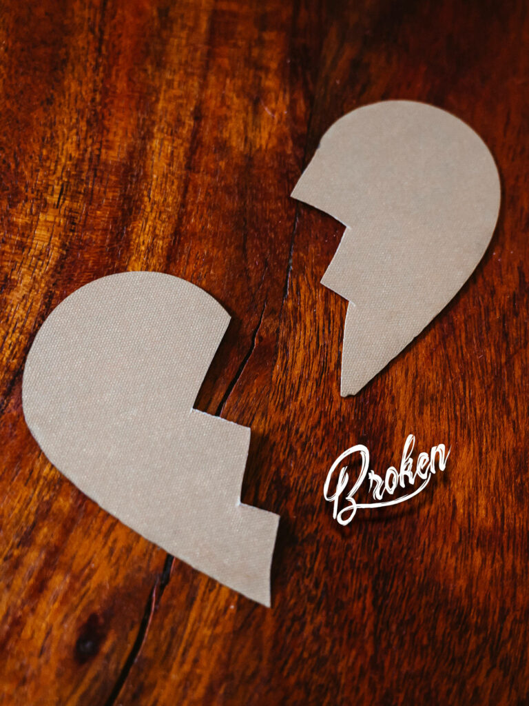 Broken heart cardboard cutout on rustic wood background minimalist brown tones wallpaper