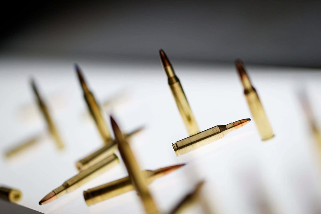 High-quality rifle cartridges with shallow focus on bright minimalist background wallpaper