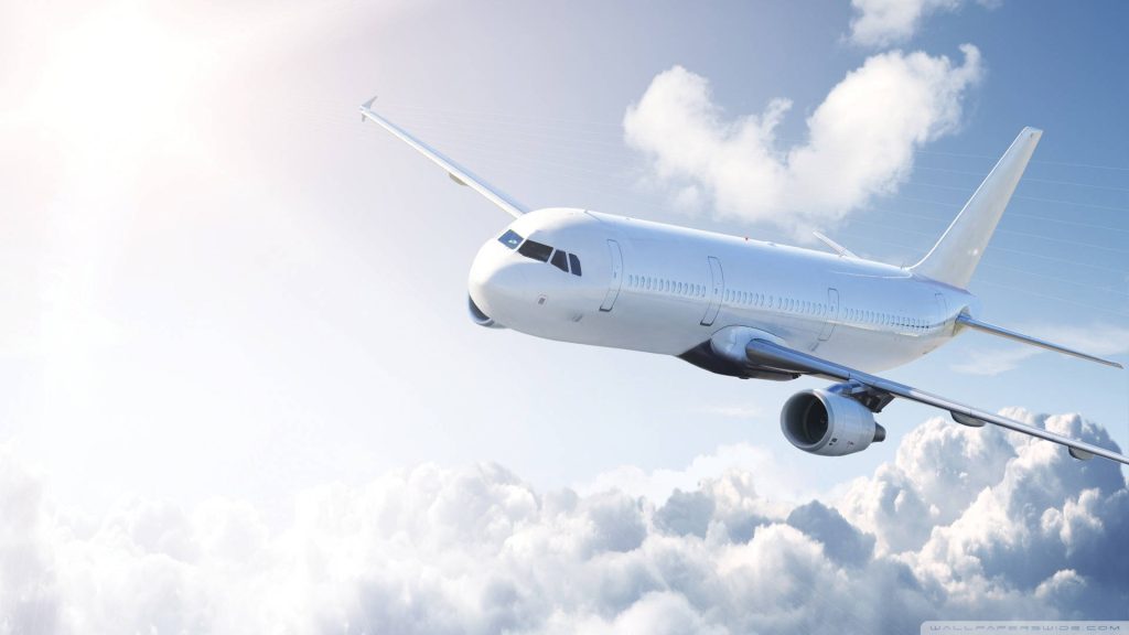 Minimalist digital art of a commercial jetliner soaring through sunlit fluffy clouds serene sky Wallpaper