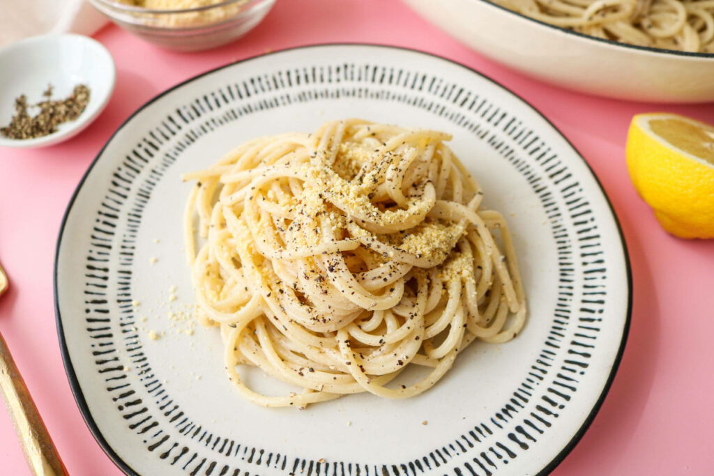 Minimalist Cacio e Pepe Wallpaper: Close-up Pasta on Pastel Pink